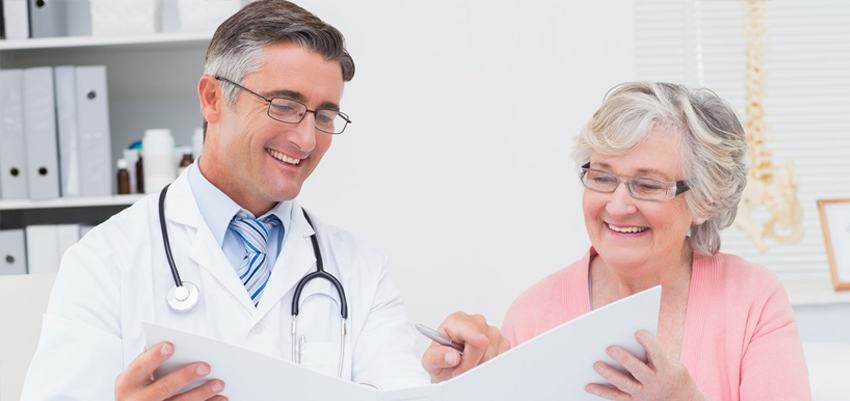 Doctor and Patient Smiling While Going Through Paperwork