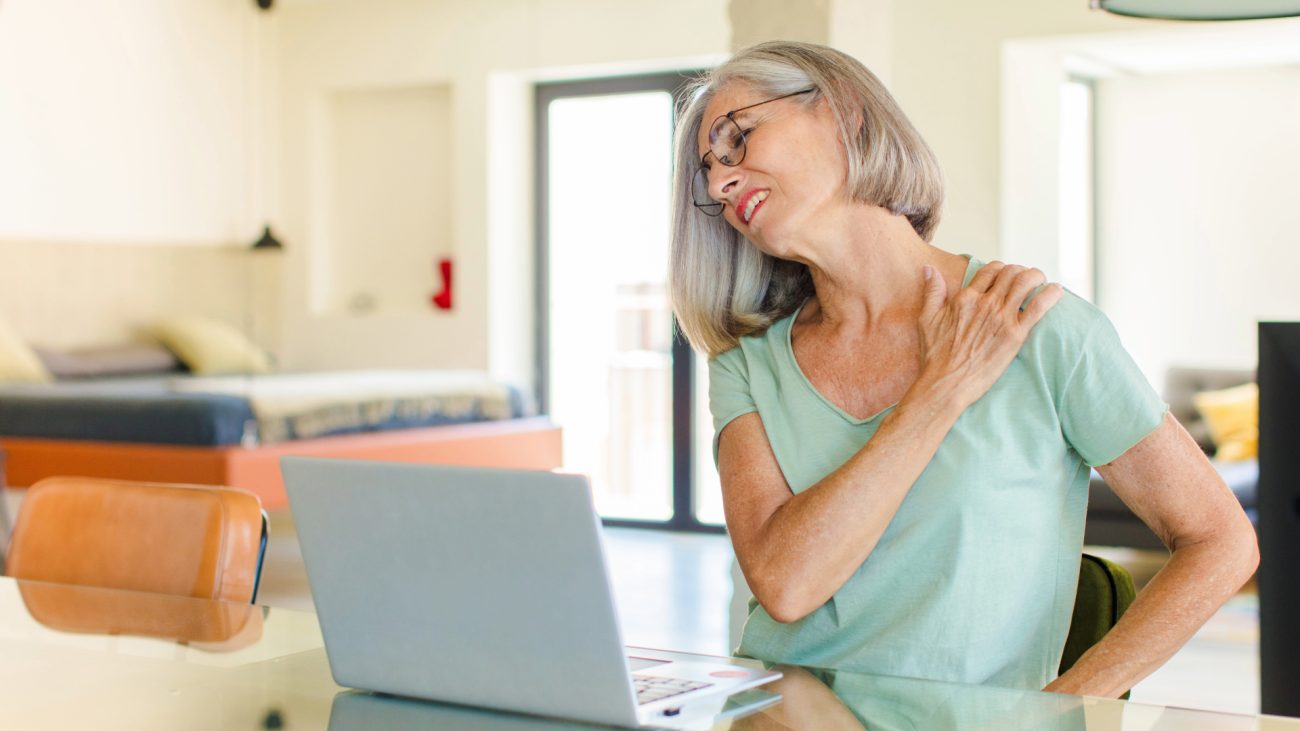 Woman holding onto her shoulder and lower back indicating neck and back pain